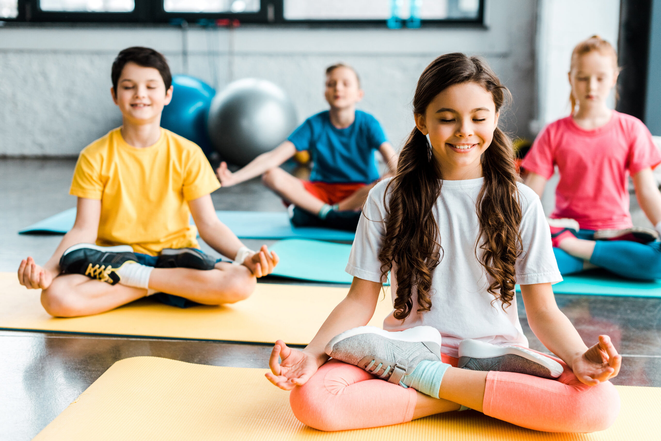 Pleased preteen kids stretching on fitness mats