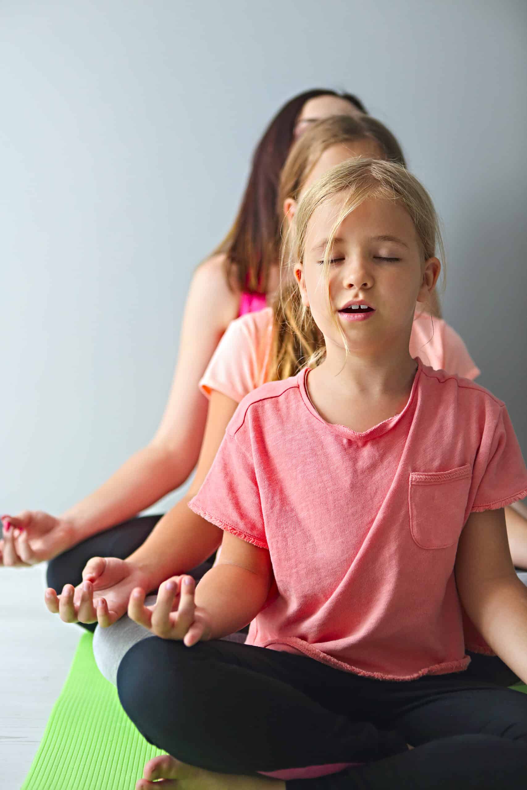 Young woman having fun with kids doing yoga yoga enfant formation
